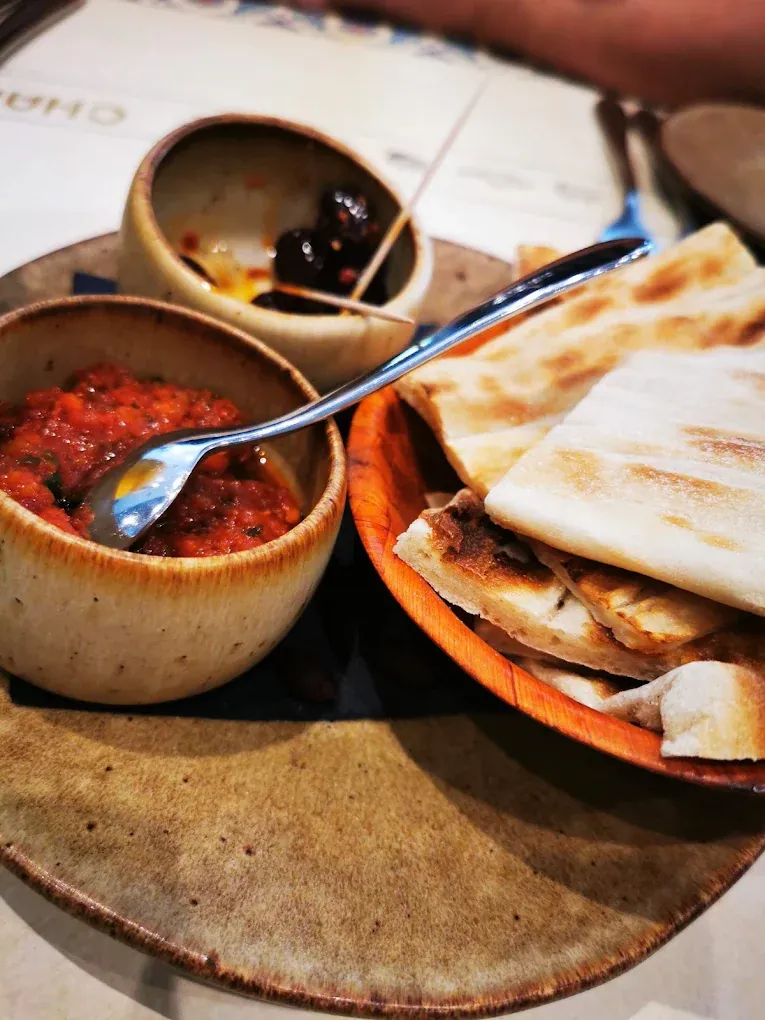 Warm Turkish flatbread with spicy ezme salsa and marinated olives